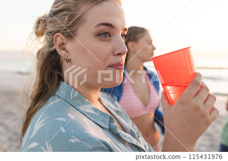 Young Caucasian women enjoy a beach sunset, with copy space 115431976