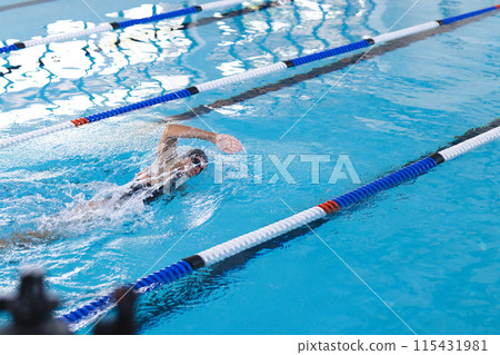 Swimmer in action at an indoor pool, with copy space Swimmer in action at an indoor pool, with copy space 115431981