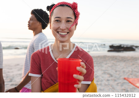 Young biracial woman smiles at the beach, with copy space 115432012