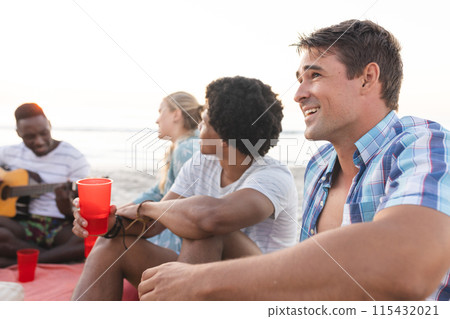 Diverse friends enjoy a beach gathering 115432021