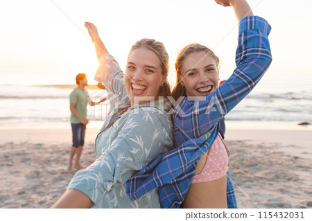 Two young Caucasian women are enjoying a beach sunset, with copy space Two young Caucasian women are enjoying a beach sunset, with copy space 115432031