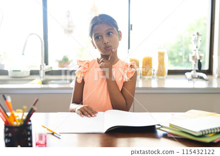 Biracial girl studying at home on a video call, engaging in online learning Biracial girl studying at home on a video call, engaging in online learning 115432122
