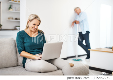 Mature, woman and home on couch with laptop, browsing and internet search or social media break in living room. Man, broom and house maintenance, married couple and weekend together in apartment Mature, woman and home on couch with laptop, browsing and internet search or social media break in living room. Man, broom and house maintenance, married couple and weekend together in apartment 115432230