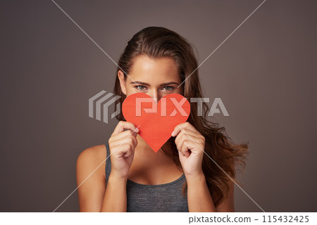 Portrait, love and woman with paper heart in studio for romance, support or donate isolated on background. Face, care or model with sign for valentines day, kindness or hide on emoji for social media 115432425