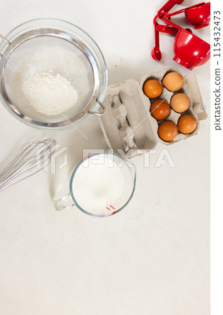 Ingredients for baking are neatly arranged on a white surface with copy space 115432473