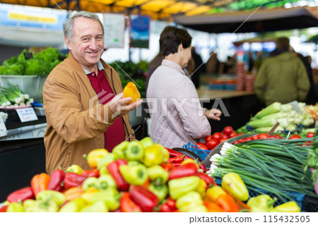 Elderly men and women buying peppers at an open market Elderly men and women buying peppers at an open market 115432505