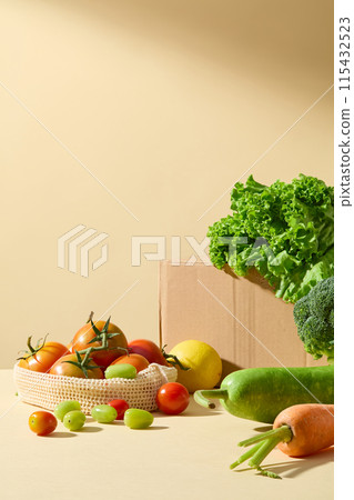 Vegetable background photo with yellow tone, fresh tomato placed in a mesh bag, nest to a paper box contains some salad, squash and carrot scattered on table. Empty space for product presentation Vegetable background photo with yellow tone, fresh tomato placed in a mesh bag, nest to a paper box contains some salad, squash and carrot scattered on table. Empty space for product presentation 115432523