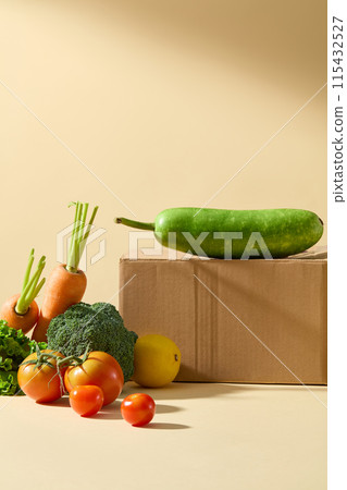A green squash is placed on top a paper box, underneath are many vegetables displayed on the table, standing out against the yellow background. Copy space for text, frontal shot 115432527