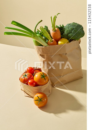 Photo of view from above on a yellow countertop contains two paper bag placed by side, both containing fresh vegetable ingredient. Advertising photo for culinary, dietary or vegetarian 115432538