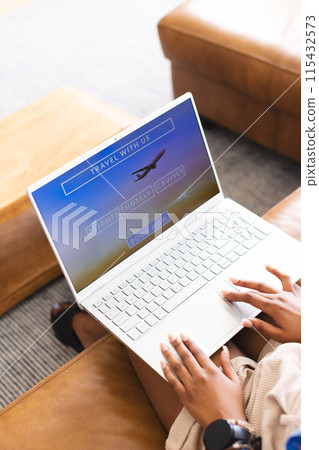 A person is browsing a travel website on a laptop 115432573