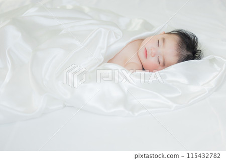 一個嬰兒裹著白布睡覺 115432782