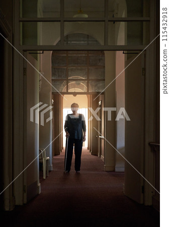 Smile, walking stick and portrait of old woman in home of living room in retirement in dark hallway. Fashion, senior and happy elderly female person with disability for confidence on cane to relax 115432918