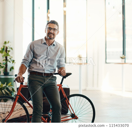 Bicycle, portrait and man in business, smile and relax in workspace, creative and confidence of entrepreneur. Brand designer, face and freelancer with flexible work, happy and rest on bike in office 115433070