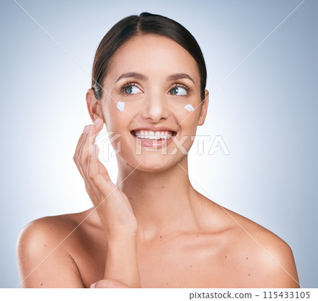 Lotion, woman and smile in studio for skincare, cream and moisturizer on blue background. Dermatology, product and girl with happiness for results, routine and cosmetics or sunscreen for protection 115433105
