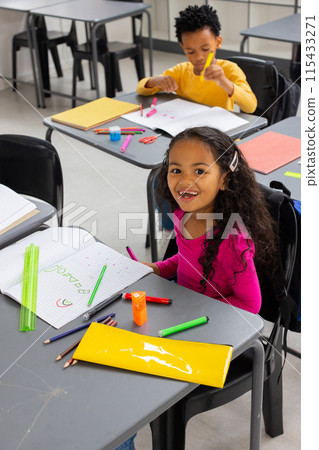 African American boy and biracial girl are focused on their schoolwork in a school classroom African American boy and biracial girl are focused on their schoolwork in a school classroom 115433271