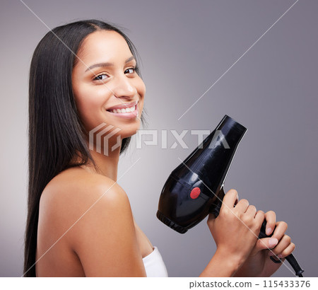 Cosmetics, woman and happy portrait with hairdryer in studio grey background for wellness and self care. Female person, heat treatment and smile with equipment isolated on backdrop for salon shine 115433376