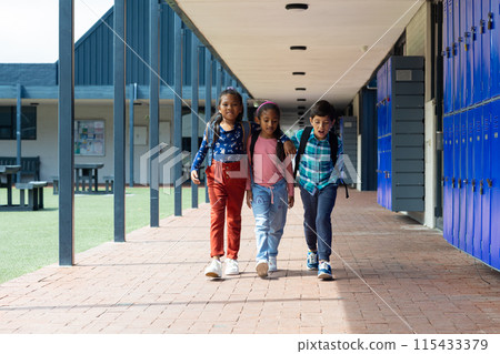 Biracial boy and girls walk together in a school corridor 115433379