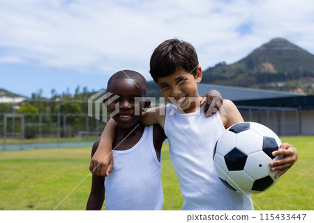 Biracial boy and African American boy smile, holding a soccer ball in school Biracial boy and African American boy smile, holding a soccer ball in school 115433447