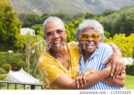 Senior African American woman and senior biracial woman share a joyful embrace outdoors Senior African American woman and senior biracial woman share a joyful embrace outdoors 115433820