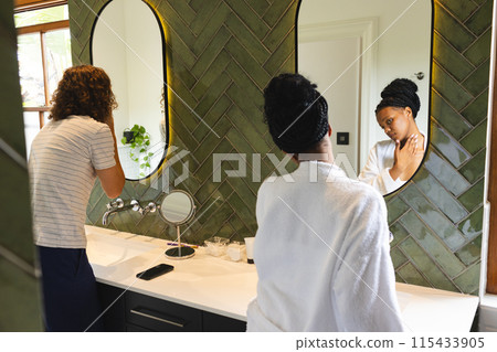 Diverse couple: young Caucasian man and African American woman stand by a bathroom sink 115433905