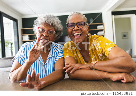Senior African American woman and senior biracial woman are sharing a joyful moment on video call at Senior African American woman and senior biracial woman are sharing a joyful moment on video call at 115433951