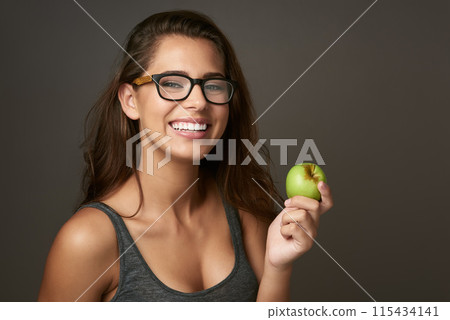 Studio background, portrait and apple with woman for eating, vitamin c and mineral for nutrition. Female nutritionist, organic fruit and healthy diet for detox, weight loss or benefits with pride 115434141
