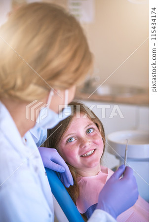 Dentist, kid and doctor talking for teeth cleaning or cavity treatment for oral hygiene or dental health. Paediatric clinic, advice and happy girl child with woman and smile for medical consultation 115434174