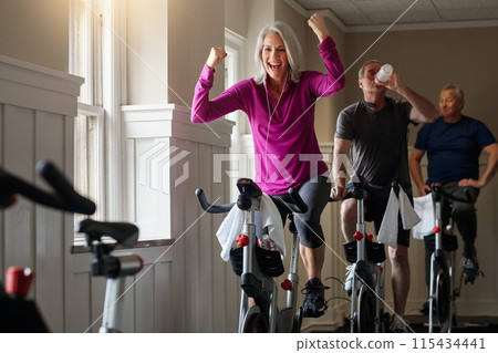 Spinning class, success or happy woman on cycling bike in workout or training for progress, health or wellness. Gym, winner or excited senior person on bicycle machine for fitness, exercise and goal 115434441