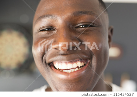 Close-up of a smiling young African American man with short black hair 115434527