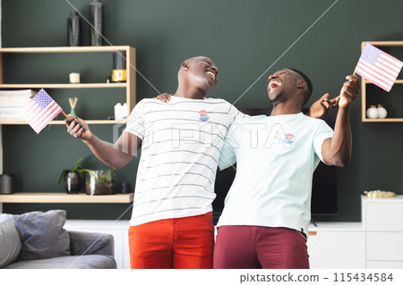 Two young African American men celebrate with American flags, wearing "I Voted" stickers Two young African American men celebrate with American flags, wearing "I Voted" stickers 115434584