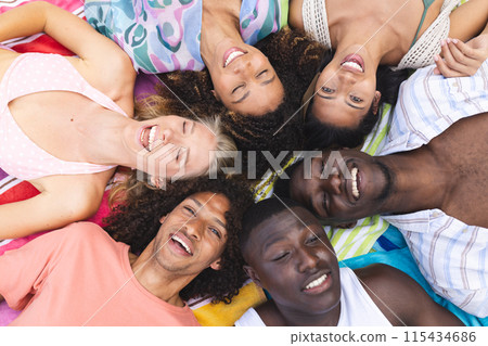 Diverse group of young adults lying in a circle, smiling upwards Diverse group of young adults lying in a circle, smiling upwards 115434686