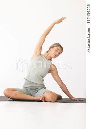 Young Caucasian woman practices yoga in a serene indoor setting with copy space Young Caucasian woman practices yoga in a serene indoor setting with copy space 115434906