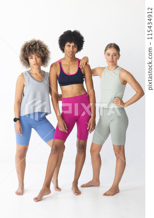 Three fit women pose confidently in athletic wear 115434912