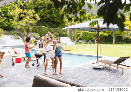 Diverse group of friends enjoying a barbecue by the poolside with copy space 115435022