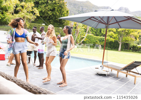 Diverse group of friends enjoying a poolside party on a sunny day Diverse group of friends enjoying a poolside party on a sunny day 115435026