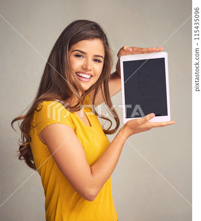 Young woman, portrait and display with tablet screen for advertising, marketing or app on a studio background. Happy female person or model with smile for technology or presentation on mockup space 115435096