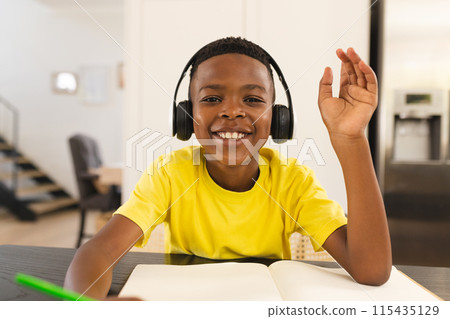 A young African American boy is engaged in a school activity on a video call online school lesson 115435129