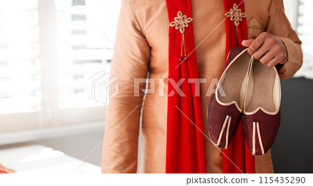 Indian, wedding and clothes for attire of shoes for groom, culture and traditional in color and choice. Stylish, fashion and suit for person in morning for marriage, selection and accessory by tailor Indian, wedding and clothes for attire of shoes for groom, culture and traditional in color and choice. Stylish, fashion and suit for person in morning for marriage, selection and accessory by tailor 115435290
