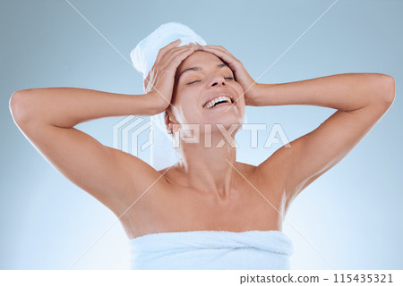 Happy, woman and cosmetics in studio blue background with towel for hygiene, haircare and self care. Female person, clean and smile isolated against backdrop for dermatology and beauty treatment Happy, woman and cosmetics in studio blue background with towel for hygiene, haircare and self care. Female person, clean and smile isolated against backdrop for dermatology and beauty treatment 115435321