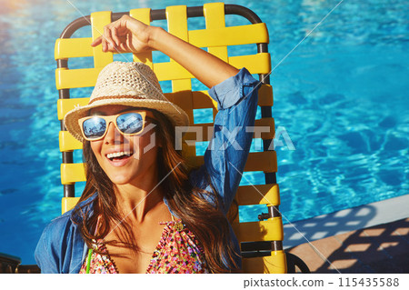 Woman, poolside and lying on holiday chair, outdoor and travel to hotel resort for vacation. Female person, peace and sunglasses by water to rest, smile and calm by swimming pool for luxury wellness 115435588