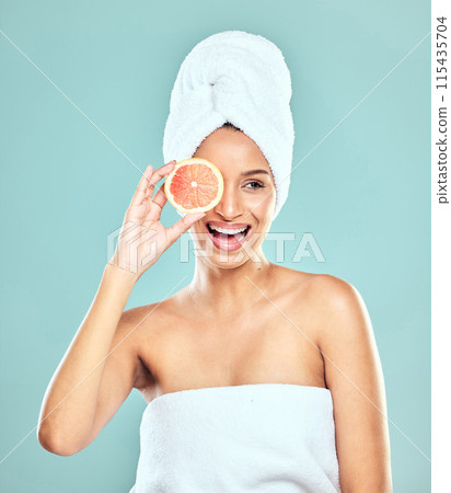 Woman, orange and citrus for skincare in studio, eco friendly and vitamin c to hydrate skin. Female person, glow and organic beauty or facial treatment after shower, cosmetics and blue background Woman, orange and citrus for skincare in studio, eco friendly and vitamin c to hydrate skin. Female person, glow and organic beauty or facial treatment after shower, cosmetics and blue background 115435704