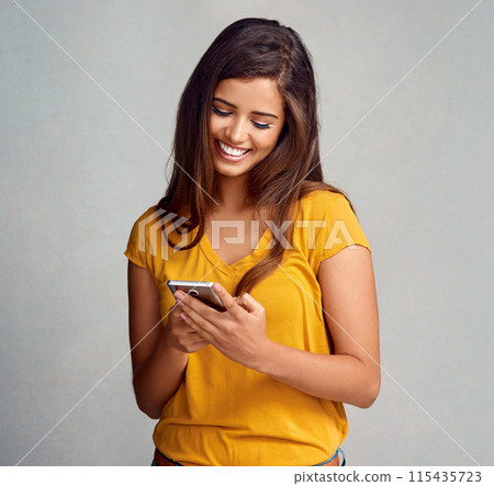 Woman, smile and notification with smartphone in studio background for social media, networking and online dating. Female person, happy and satisfied with good news, text message and entertainment 115435723