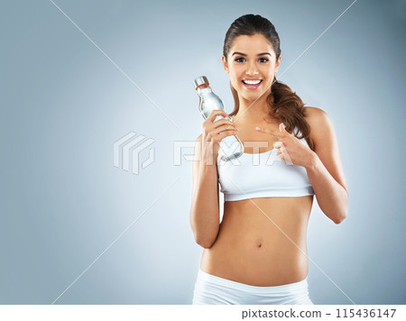 Happy woman, portrait or pointing to water in studio marketing exercise, workout or fitness training. Blue background, healthy girl or sports athlete advertising liquid bottle for mockup or hydration Happy woman, portrait or pointing to water in studio marketing exercise, workout or fitness training. Blue background, healthy girl or sports athlete advertising liquid bottle for mockup or hydration 115436147