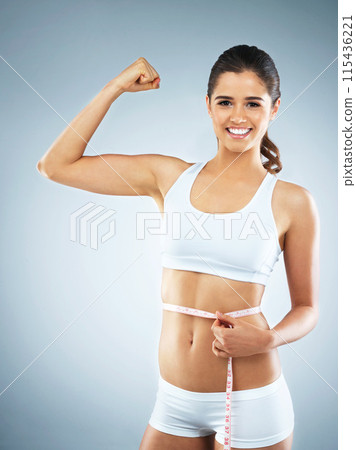 Waist, flex or portrait of woman with tape measure for fitness, body progress or workout in studio. Strong muscle, proud or happy athlete with girl power or training to lose weight on blue background Waist, flex or portrait of woman with tape measure for fitness, body progress or workout in studio. Strong muscle, proud or happy athlete with girl power or training to lose weight on blue background 115436221