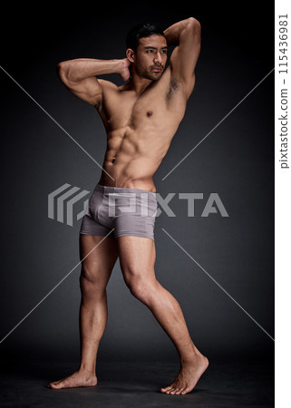 Fitness, asian man and bodybuilder flexing abs and strong body in sexy underwear isolated in studio. Health, seductive and male person with stomach muscles from training and workout challenge 115436981