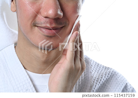 Cropped shot smiling man cleaning his face with cotton pad over white background 115437159