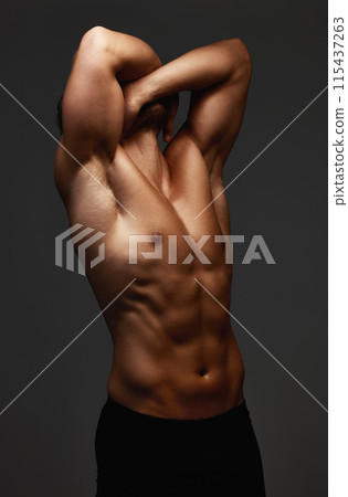 Stretch, stomach and bodybuilder in studio for exercise, training and fitness for health. Sportsman, athlete and shirtless for wellness by dark background for transformation, workout and abs Stretch, stomach and bodybuilder in studio for exercise, training and fitness for health. Sportsman, athlete and shirtless for wellness by dark background for transformation, workout and abs 115437263