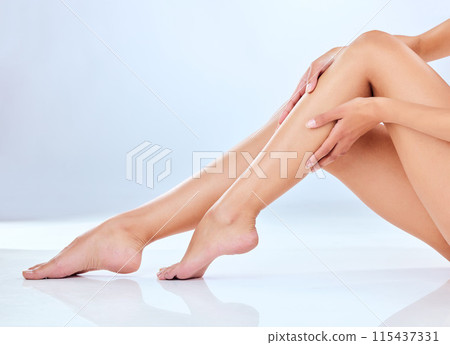 Legs, skincare and hands for woman in studio, feet and waxing on white background. Hair removal, floor and hygiene for smooth skin for epilation, bodycare or wellness for pamper and spa treatment 115437331