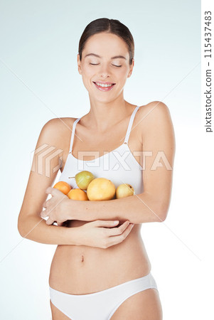 Happy woman, fruit and underwear in studio for health, diet and nutrition on white background. Female nutritionist, food and hands with smile for wellness, self care and vitamins for wellbeing Happy woman, fruit and underwear in studio for health, diet and nutrition on white background. Female nutritionist, food and hands with smile for wellness, self care and vitamins for wellbeing 115437483