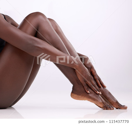 Skincare, black person and legs in studio for hair removal, epilation and smooth skin on white background. Body, woman and hands touching with manicure for wellness, waxing and moisturize for beauty 115437770